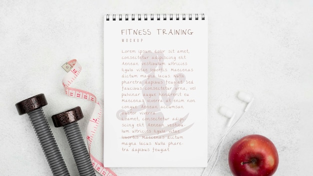 Lay piatto di notebook fitness con mela e pesi