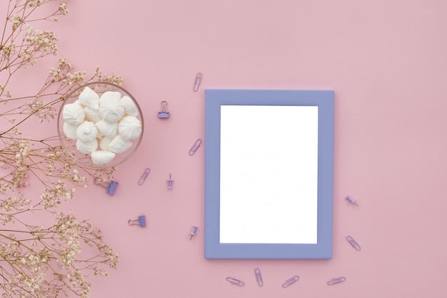 Flat lay flowers, photo frame on pink table