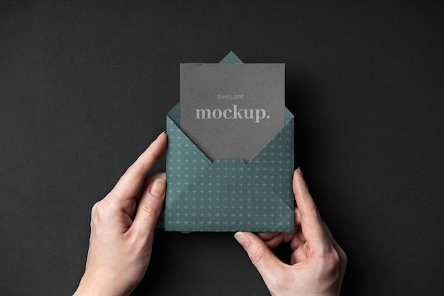 Flat lay hands holding dark envelope