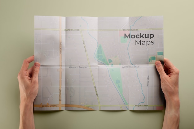 PSD flat lay hands holding map mockup