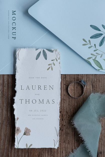 Flat lay of mock-up rustic paper wedding invitation with leaves and flowers