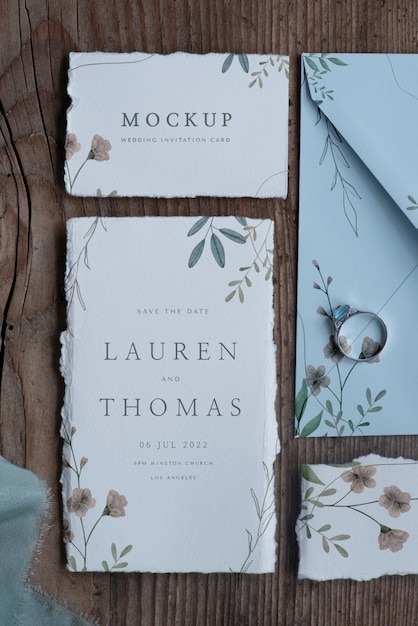 葉と花のモックアップ素朴な紙の結婚式の招待状のフラットレイ