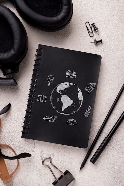 Mock-up e penna per notebook flat lay vicino con occhiali e cuffie