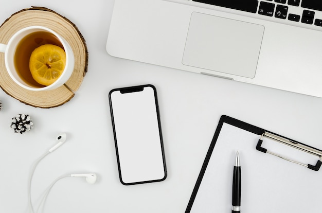 PSD flat lay smartphone mock-up with earphones on desk