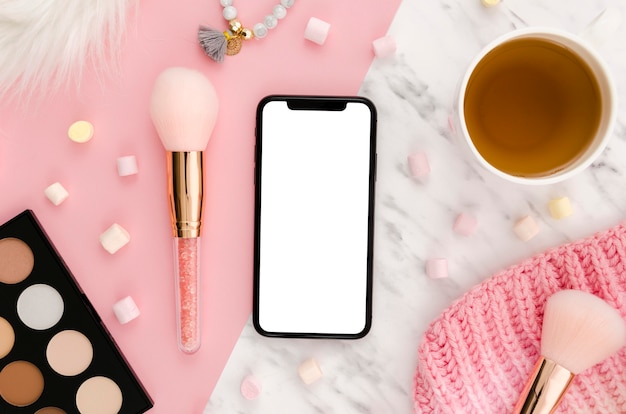 Flat lay smartphone mock-up with make-up palette and coffee on desk