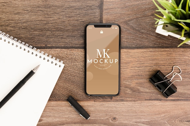 PSD flat lay smartphone mock-up with motepad on desk