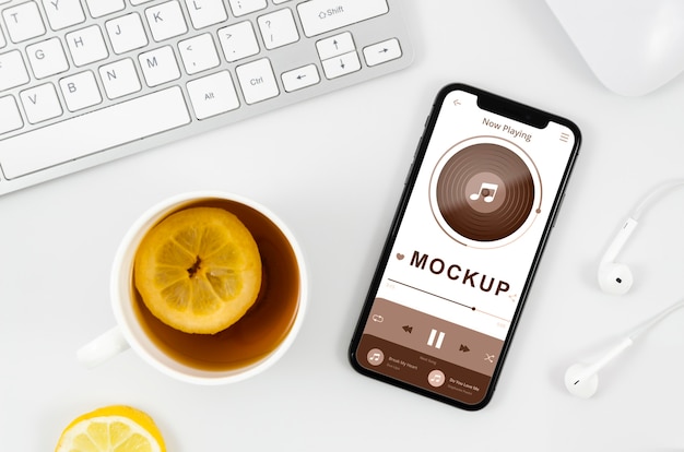 Mock-up di smartphone piatto laici con tè sulla scrivania