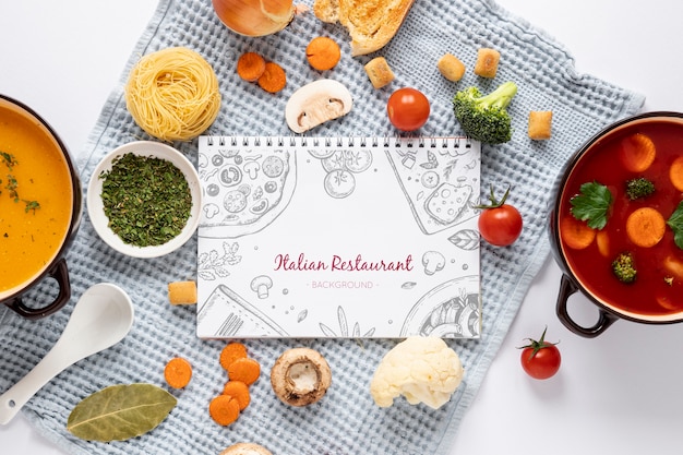 Flat lay soup with assortment of ingredients and notepad mock-up