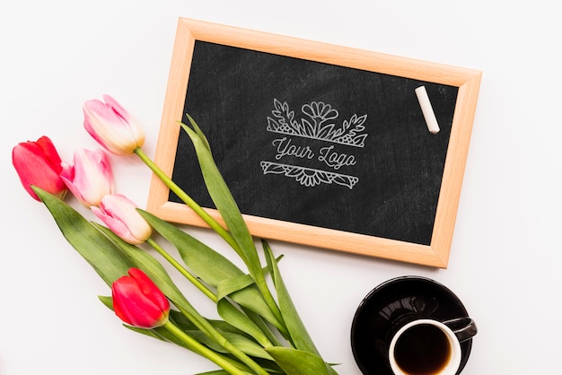 Flowers on blackboard and coffee cup