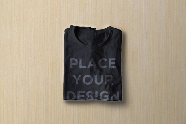 folded blank black tshirt mockup on a solid wooden background