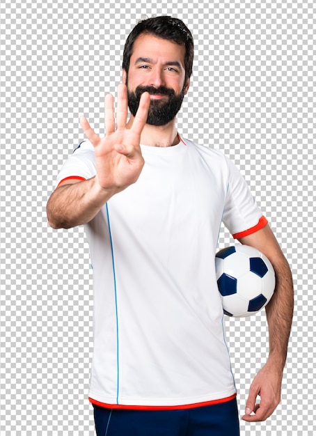 Football player holding a soccer ball counting four