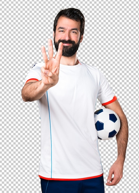 Football player holding a soccer ball counting three