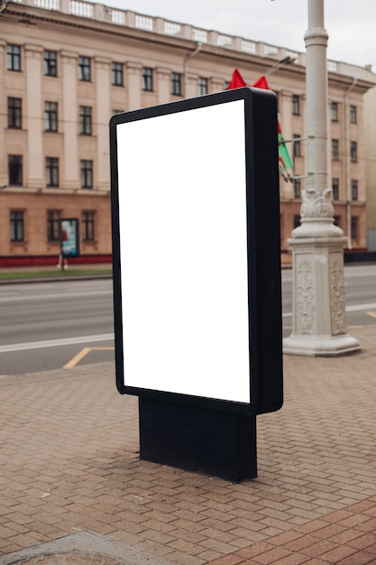 Foto van een groot reclamebord dat op straat staat, waar veel mensen lopen