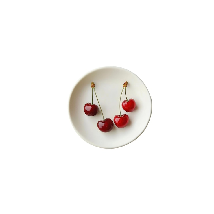 PSD four cherries on a white plate
