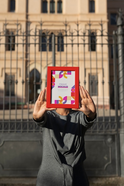 Frame mockup held by person outside