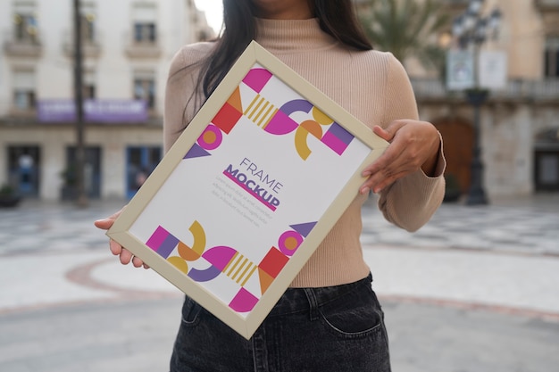 frame mockup held by person outside