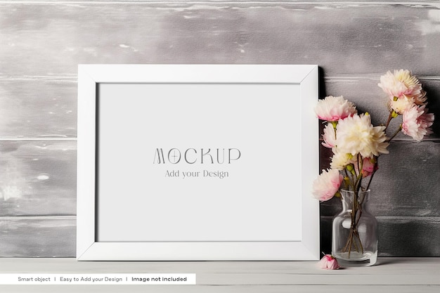 Free white frame psd mockup with flowers in a vase on a wooden table