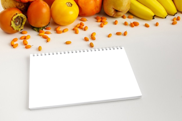 Fresh autumn yellow and orange vegetables and fruits and notebook