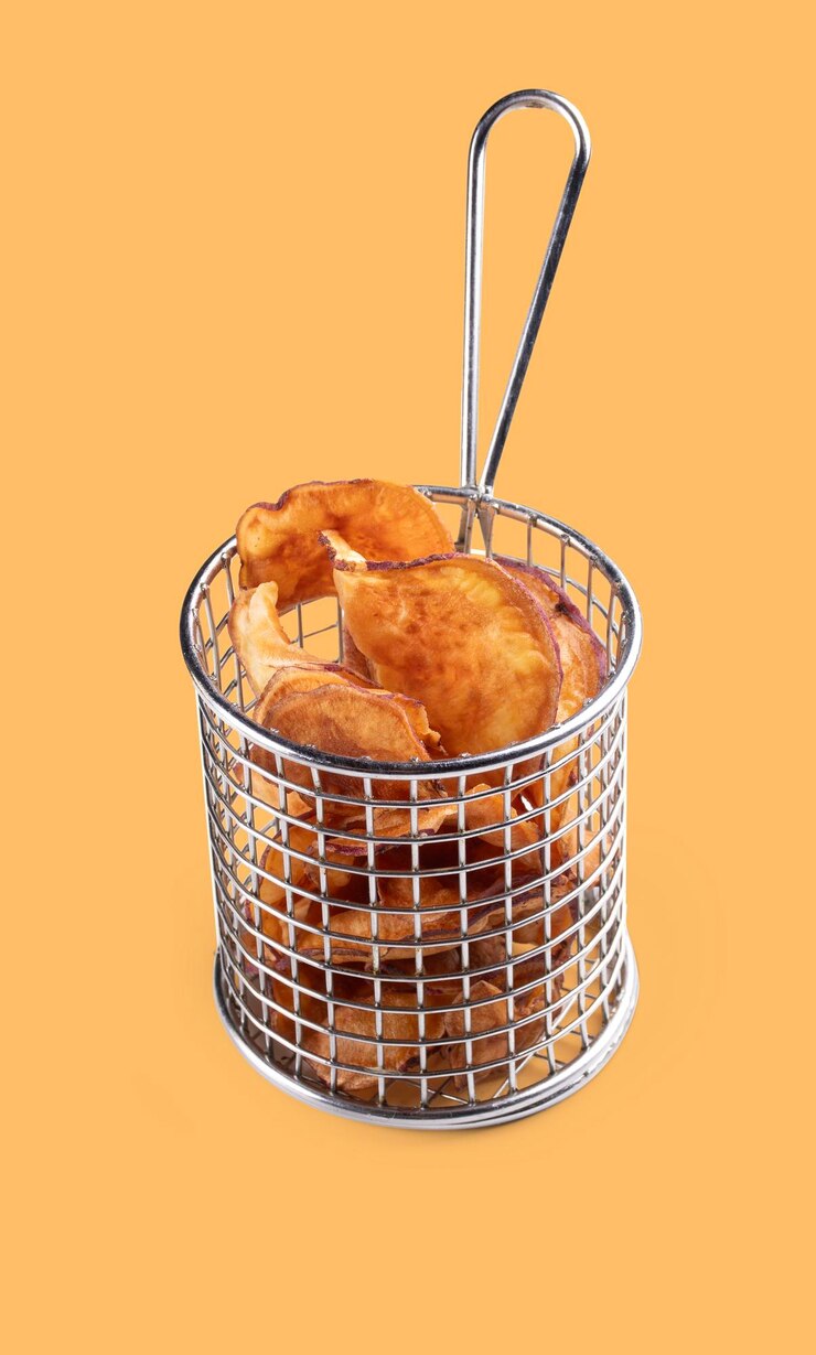 PSD fried sweet potato chips in stainless steel fryer basket isolated