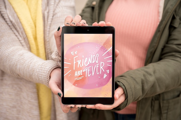 PSD friend holding happy friendship day tablet