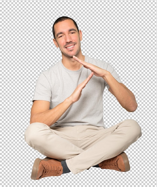 Friendly young man making a time out gesture with his hands