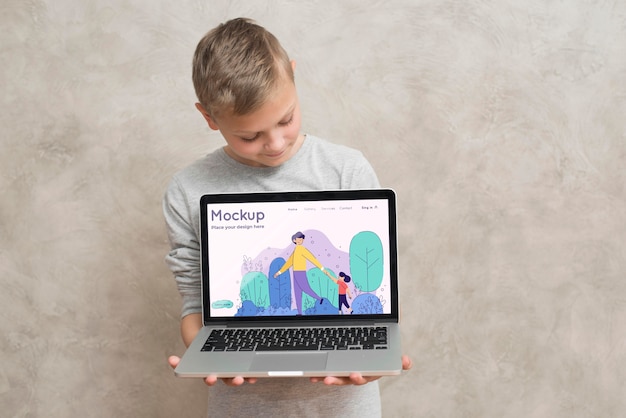 Front view of boy holding laptop