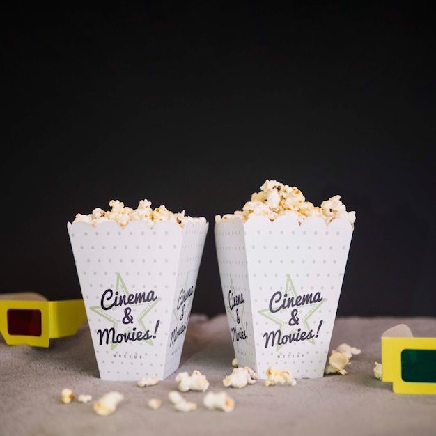 Front view of cinema glasses and cups of popcorn