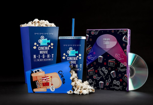 Front view of cinema popcorn cups with straw and dvd