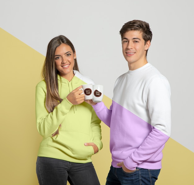 Front view of couple holding mugs