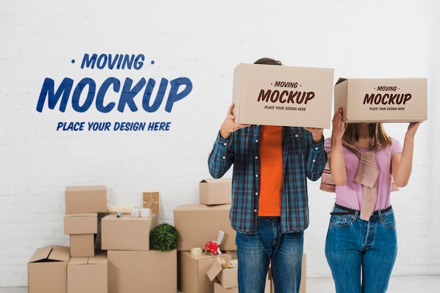 Front view of couple posing with moving boxes mock-up