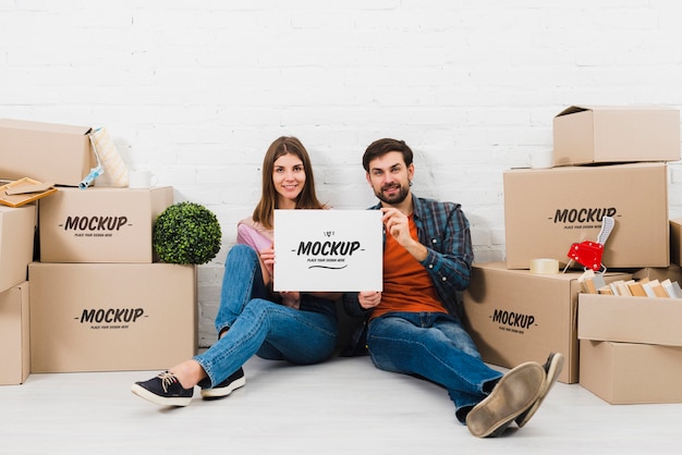 Front view of couple posing with moving boxes