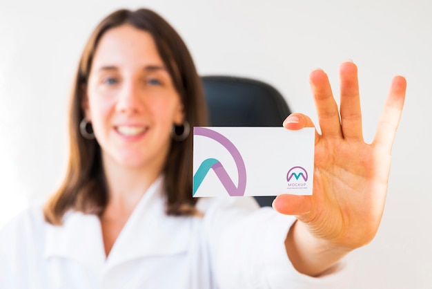 Front view of defocused businesswoman holding business card