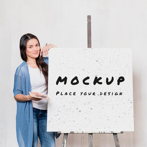 front view of female artist with mock-up easel and canvas