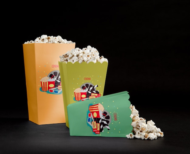 Vista frontale delle tazze riempite del popcorn del cinema