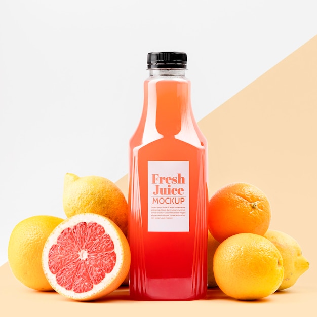 Front view of glass juice bottle with grapefruit and lemons