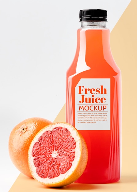 Front view glass juice bottle with grapefruit