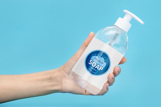 PSD front view of hand holding bottle of liquid soap