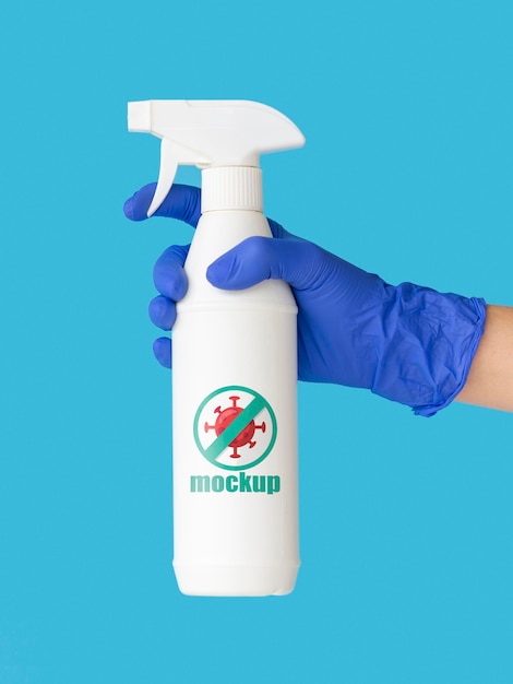 PSD mano di vista frontale con guanto che tiene il mock-up della bottiglia di disinfezione