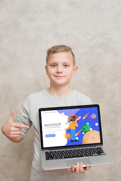 PSD front view of kid holding and pointing at laptop