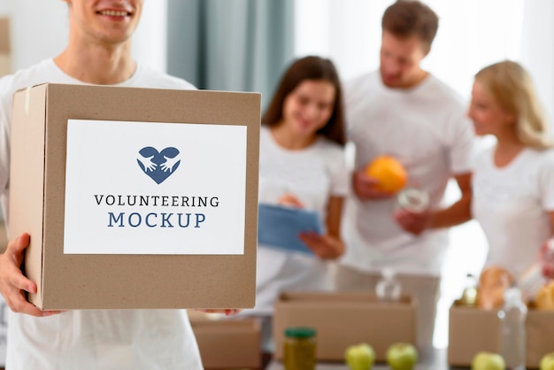front view of male volunteer holding box with donations