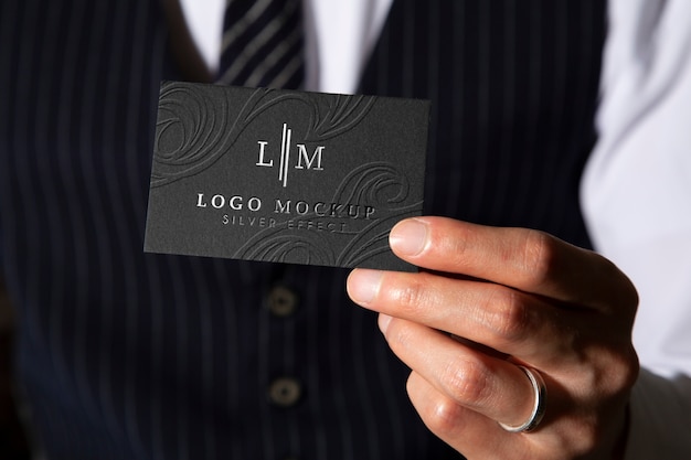 Front view man holding business card with silver logo