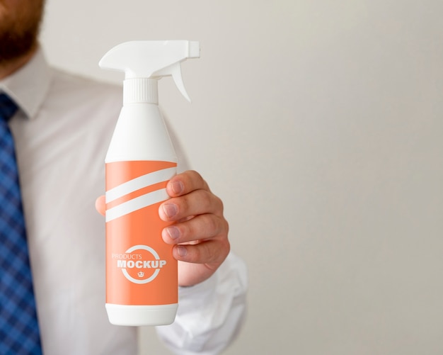 Front view man holding a cleaning bottle with copy space
