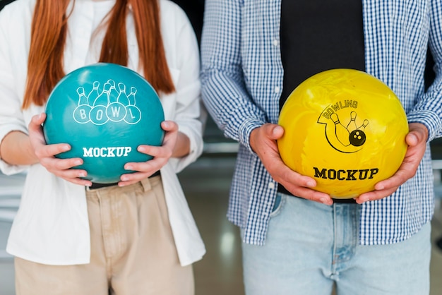 Vista frontale dell'uomo e della donna che tengono le palle da bowling