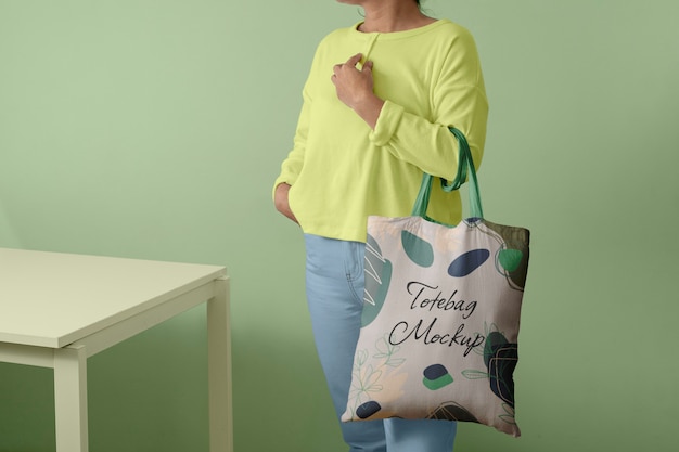 Front view of person holding tote bag mock-up