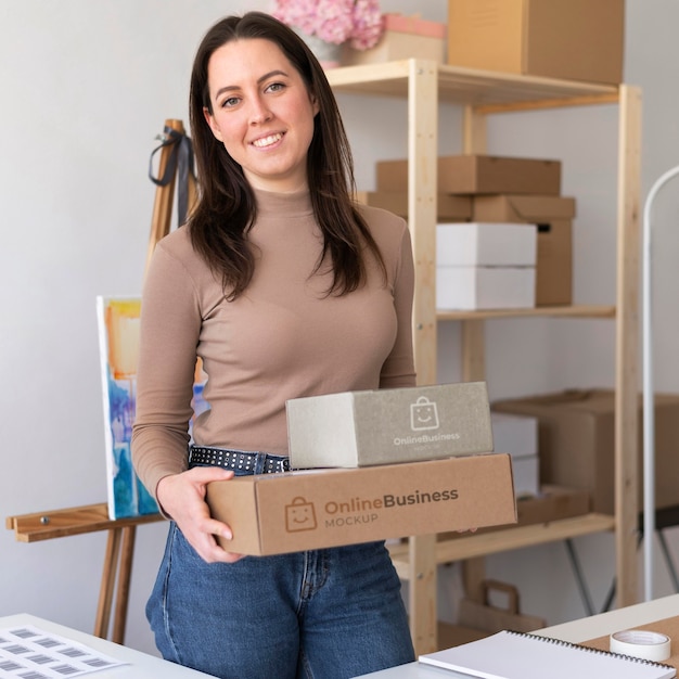 PSD front view smiley woman holding boxes