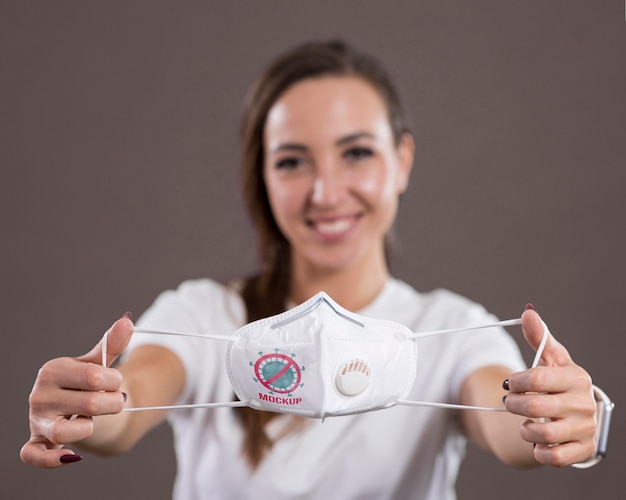 PSD front view of smiley woman holding a mask