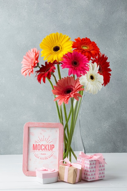 Front view of vase with daisies with frame and gifts