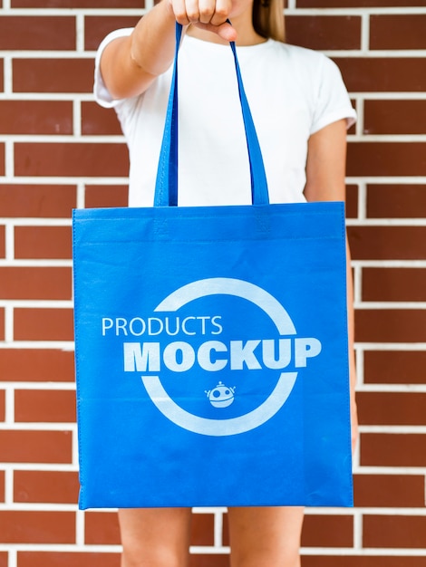 Front view woman holding a plain blue bag