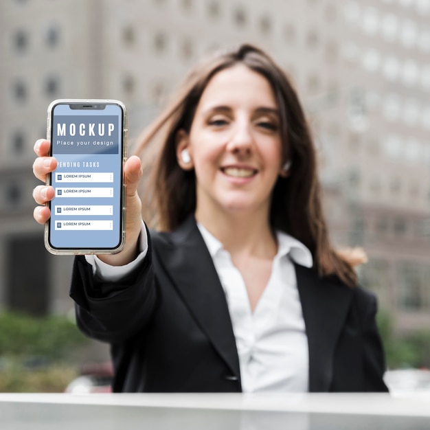 PSD front view of woman holding a smartphone mock-up