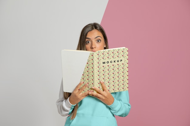 Front view of woman holding up book